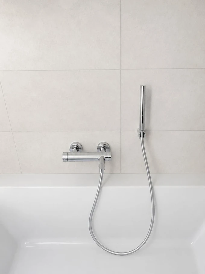 Baignoire avec mitigeur mural et douchette à main