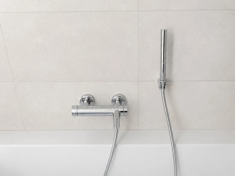 Baignoire avec mitigeur mural et douchette à main