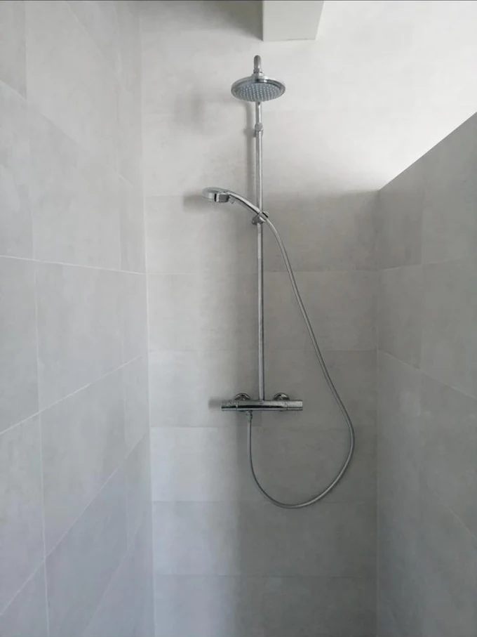 Colonne de douche thermostatique dans une douche carrelée