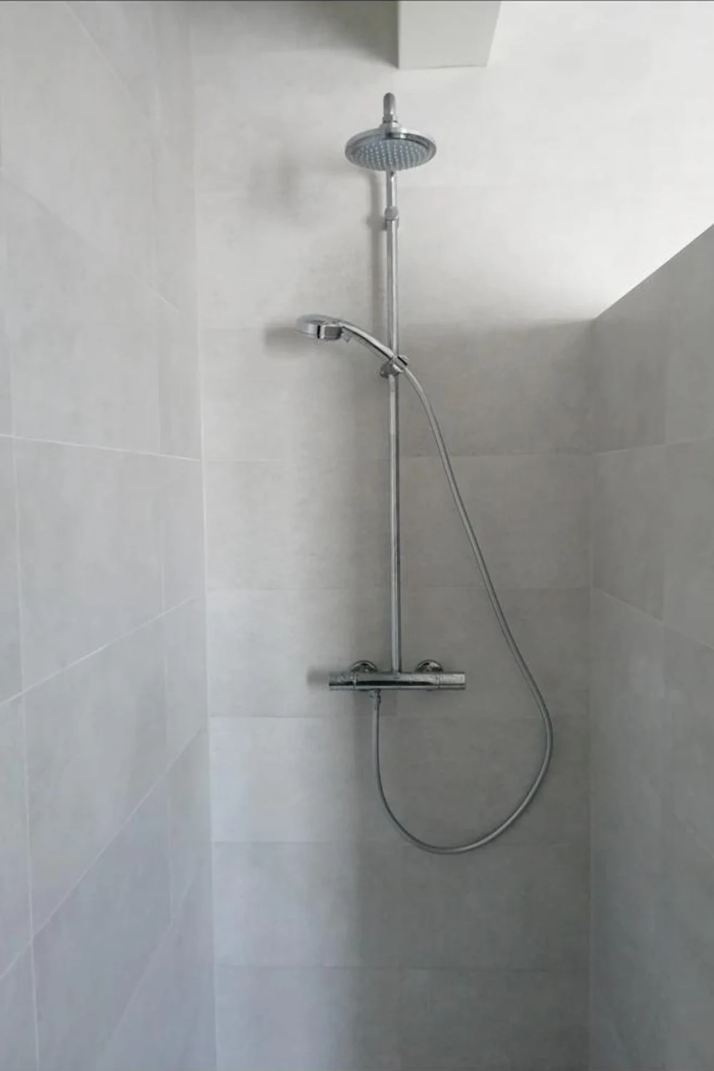 Colonne de douche thermostatique dans une douche carrelée
