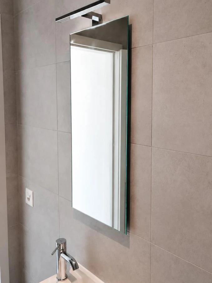 Lavabo d'angle surmonté d'un miroir et d'une applique
