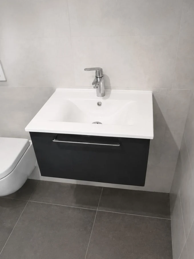 Meuble vasque suspendu foncé et WC suspendu, carrelage gris