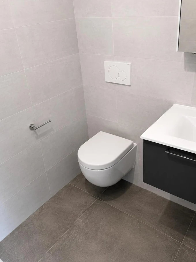 WC suspendu et meuble lave-mains anthracite dans une salle d'eau