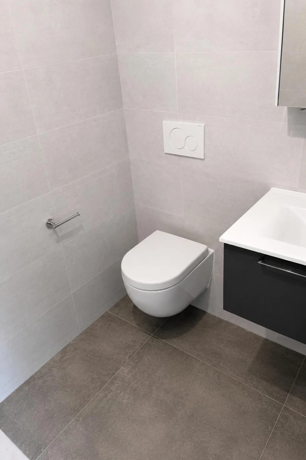 WC suspendu et meuble lave-mains anthracite dans une salle d'eau