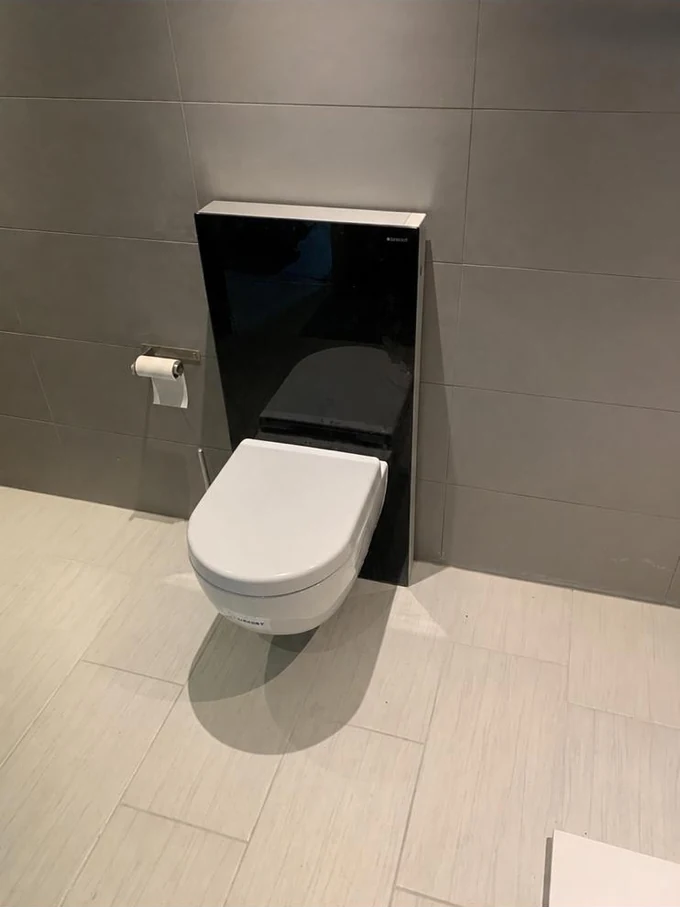 WC suspendu avec habillage de réservoir foncé